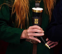 Drinking horn with brass rim and tip, with brown holder decorated with quatrefoil mounts